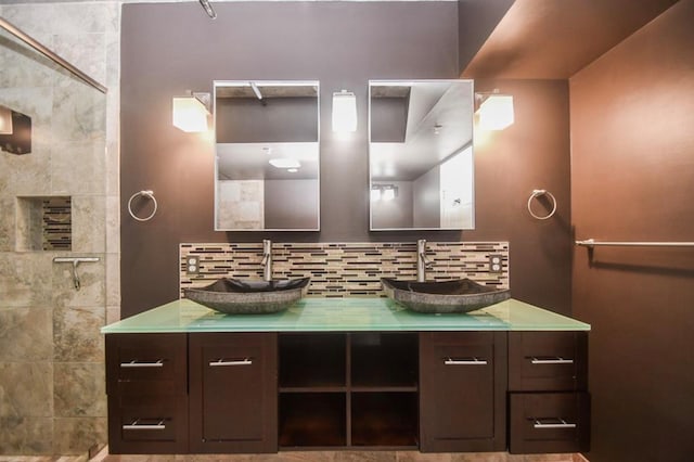 bathroom featuring vanity, decorative backsplash, and a tile shower