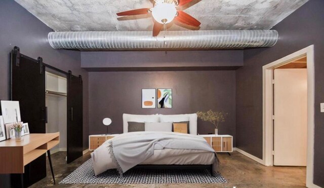 bedroom featuring concrete floors, a barn door, and ceiling fan