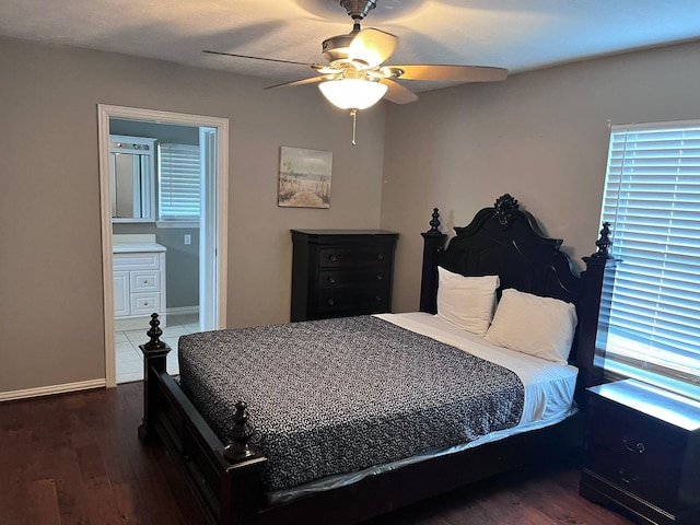 bedroom with dark wood-type flooring, ceiling fan, and ensuite bathroom