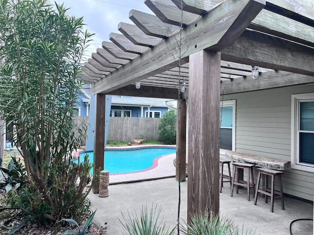 view of swimming pool featuring a patio, a pergola, and a bar