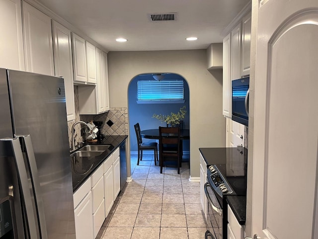 kitchen featuring black appliances, sink, tasteful backsplash, light tile patterned floors, and white cabinetry