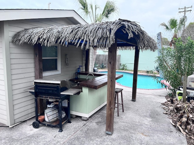 view of pool featuring area for grilling and a patio area