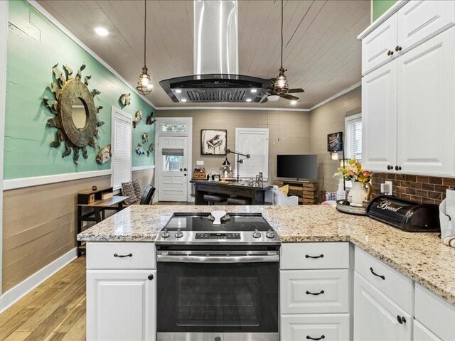 kitchen with electric range, light hardwood / wood-style flooring, pendant lighting, island range hood, and white cabinets