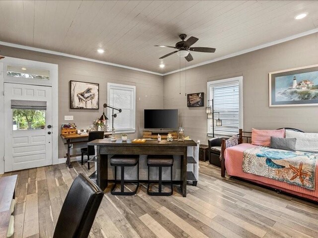 bedroom featuring multiple windows, light wood-type flooring, ceiling fan, and ornamental molding