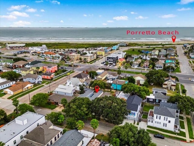 birds eye view of property with a water view and a beach view