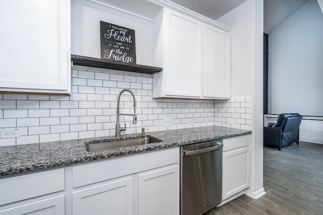 kitchen featuring white cabinets, dishwasher, dark stone countertops, and sink