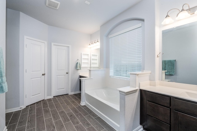 bathroom featuring a washtub and vanity