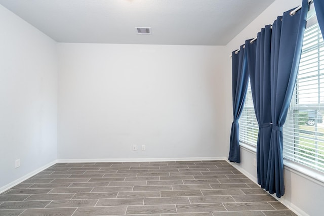 unfurnished room with a healthy amount of sunlight and wood-type flooring