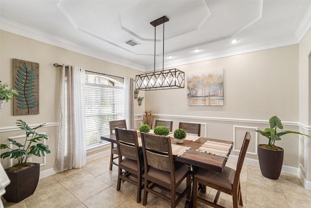 dining space featuring light tile patterned floors, a tray ceiling, and ornamental molding