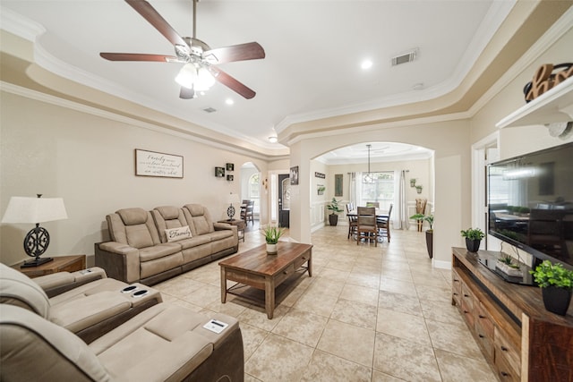 tiled living room featuring a tray ceiling, ceiling fan, and crown molding