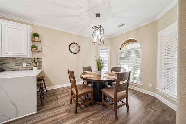 dining room with dark hardwood / wood-style flooring, an inviting chandelier, and crown molding