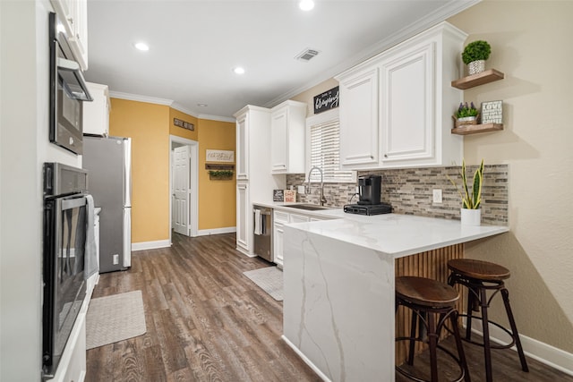 kitchen with kitchen peninsula, sink, and white cabinets