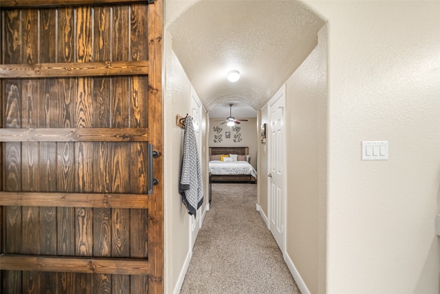 hall featuring carpet floors and a textured ceiling