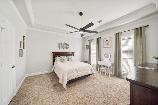 bedroom with ceiling fan, crown molding, light carpet, and a tray ceiling