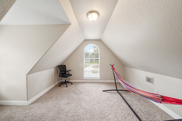 rec room featuring a textured ceiling, carpet floors, and vaulted ceiling