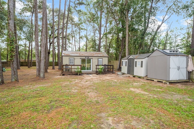 rear view of house with a lawn and a storage shed