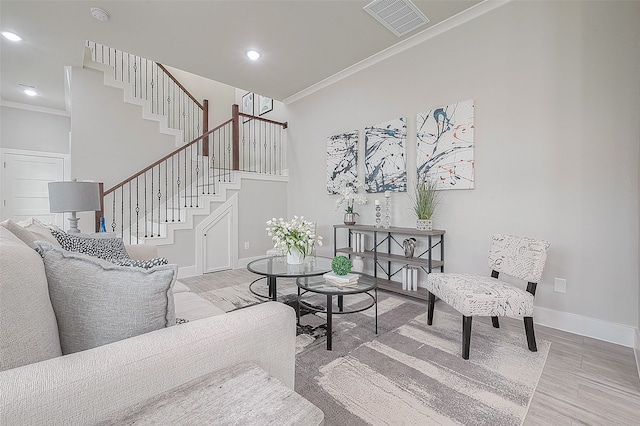 living room with light hardwood / wood-style floors and crown molding