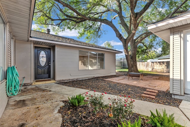 view of exterior entry with a patio area