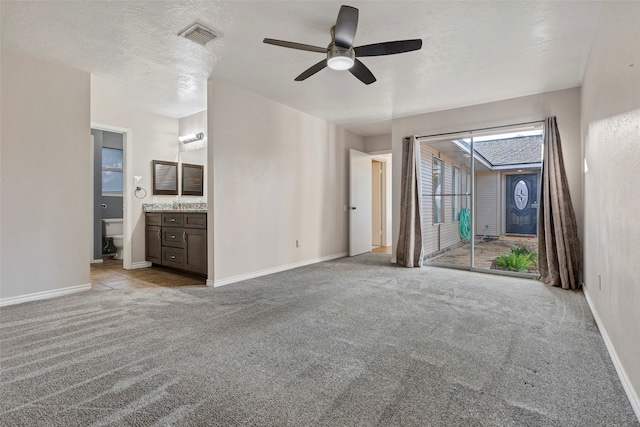 unfurnished living room featuring a textured ceiling, light colored carpet, and ceiling fan