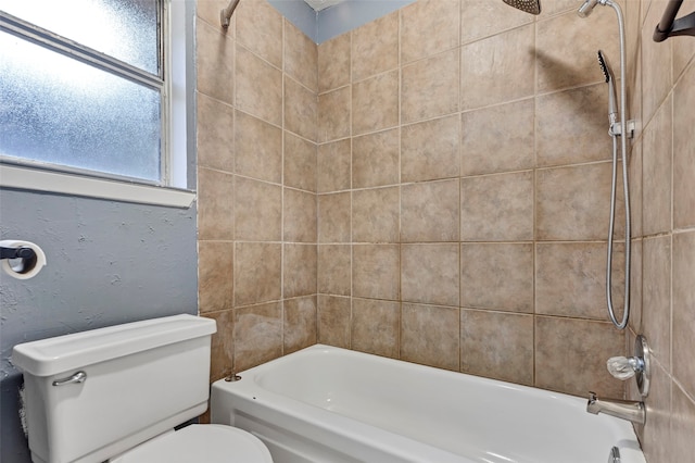 bathroom featuring toilet and tiled shower / bath combo