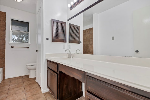 bathroom featuring toilet, vanity, and tile patterned flooring