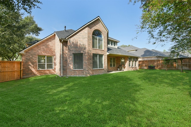 back of property with a lawn and a patio