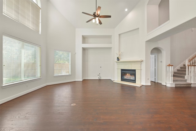 unfurnished living room with dark hardwood / wood-style flooring, ceiling fan, and high vaulted ceiling