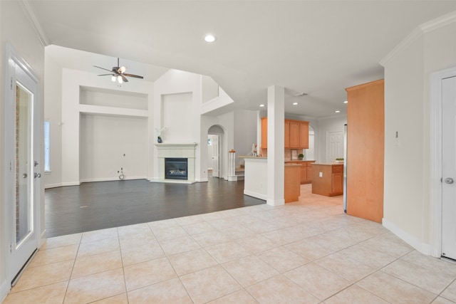 unfurnished living room featuring light wood-type flooring, ceiling fan, and ornamental molding