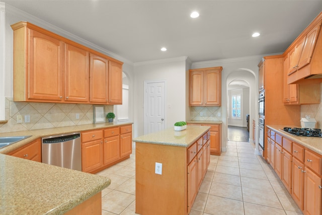 kitchen featuring crown molding, stainless steel appliances, light tile patterned flooring, and a kitchen island