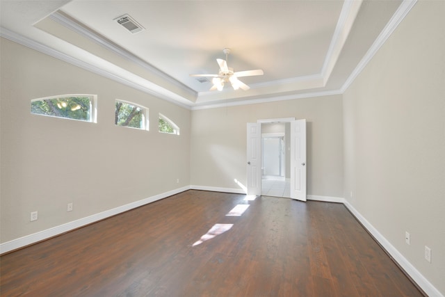 spare room with ceiling fan, crown molding, dark hardwood / wood-style flooring, and a tray ceiling