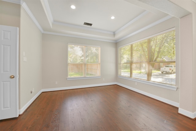 spare room with dark hardwood / wood-style floors, a raised ceiling, and crown molding