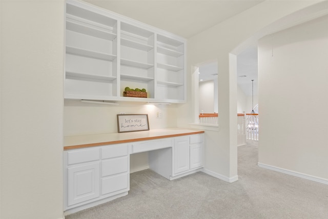 unfurnished office with light colored carpet and built in desk