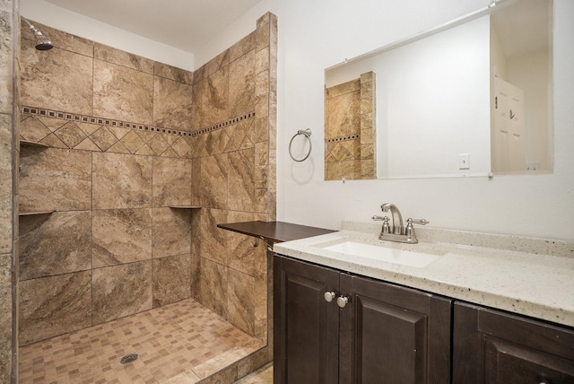 bathroom with vanity and a tile shower