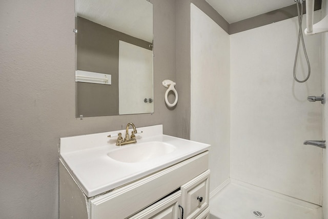 bathroom featuring a shower and vanity