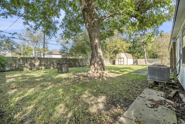 view of yard with central AC and a storage shed