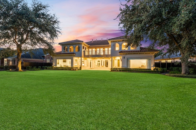 back house at dusk with a yard