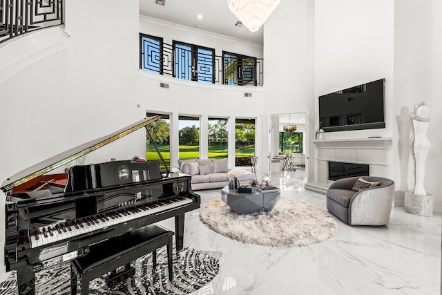 living room with a high ceiling, a tile fireplace, and crown molding