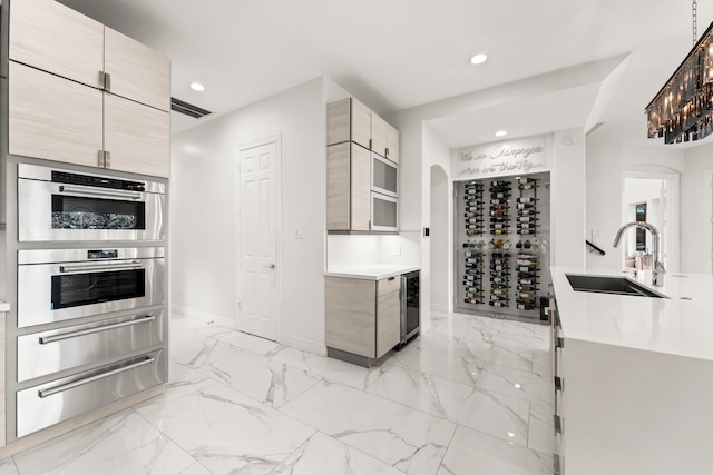 kitchen with light brown cabinets, sink, stainless steel double oven, and wine cooler