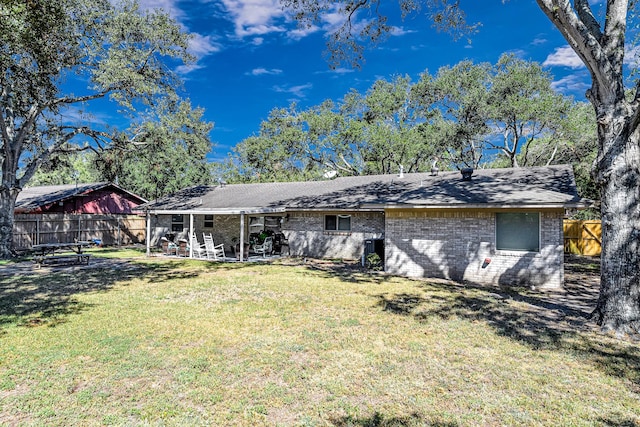 rear view of house with a lawn and a patio area