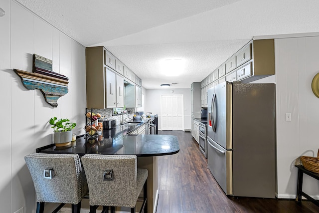 kitchen featuring kitchen peninsula, a breakfast bar, sink, stainless steel fridge with ice dispenser, and dark hardwood / wood-style floors