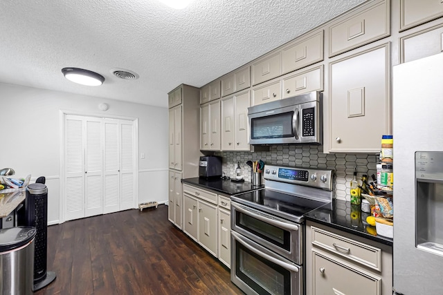 kitchen with gray cabinets, a textured ceiling, appliances with stainless steel finishes, tasteful backsplash, and dark hardwood / wood-style flooring