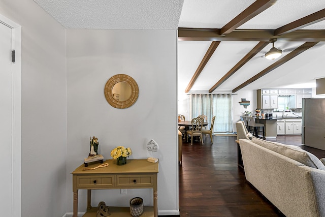 hall with beamed ceiling, a textured ceiling, dark hardwood / wood-style flooring, and sink