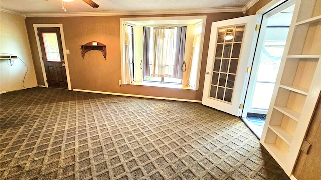 interior space featuring a textured ceiling, a wealth of natural light, ceiling fan, and crown molding