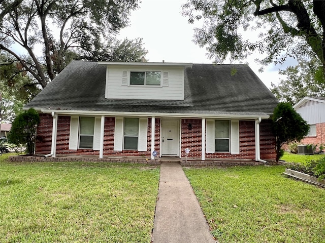 view of front facade featuring central AC unit, a front yard, and covered porch