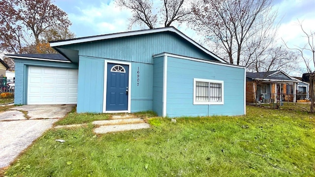 single story home featuring a garage and a front lawn