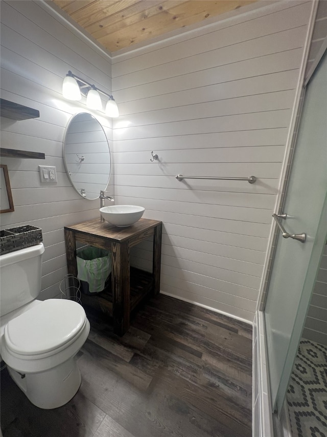 bathroom with wood-type flooring, toilet, wood walls, wooden ceiling, and vanity