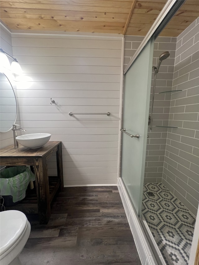 bathroom with wood walls, hardwood / wood-style flooring, a shower with door, wood ceiling, and toilet