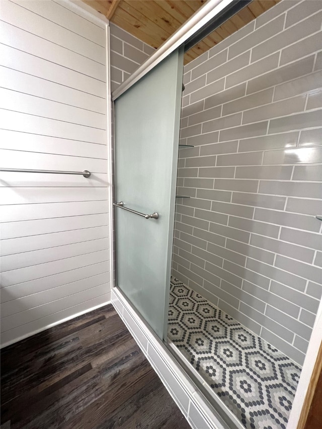 bathroom with walk in shower, wood walls, wood-type flooring, and wooden ceiling