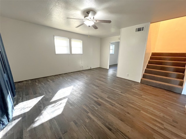 empty room featuring ceiling fan, a textured ceiling, and dark hardwood / wood-style floors