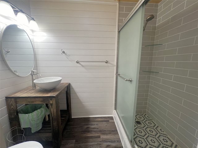 bathroom featuring walk in shower, wood walls, and hardwood / wood-style floors